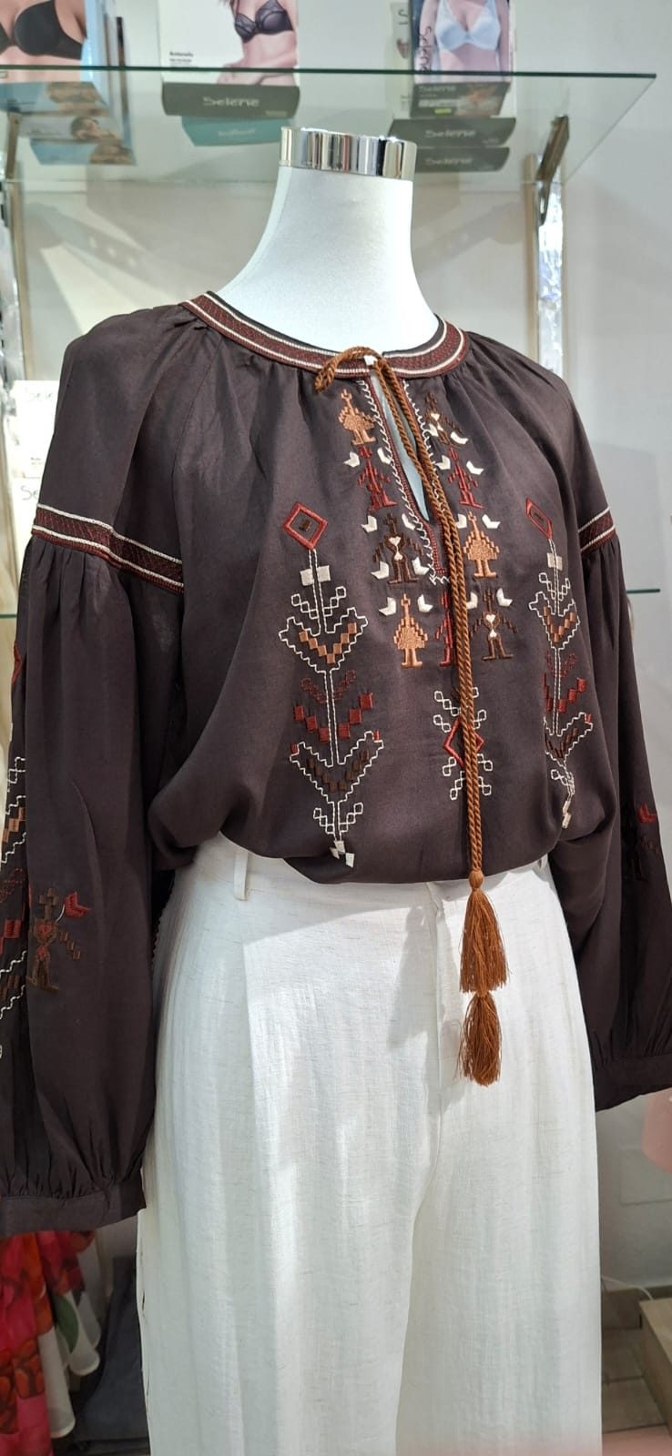 Bluzë greke e qëndisur me motive tradicionale dhe xhufkë, mbi pantallona liri të bardha